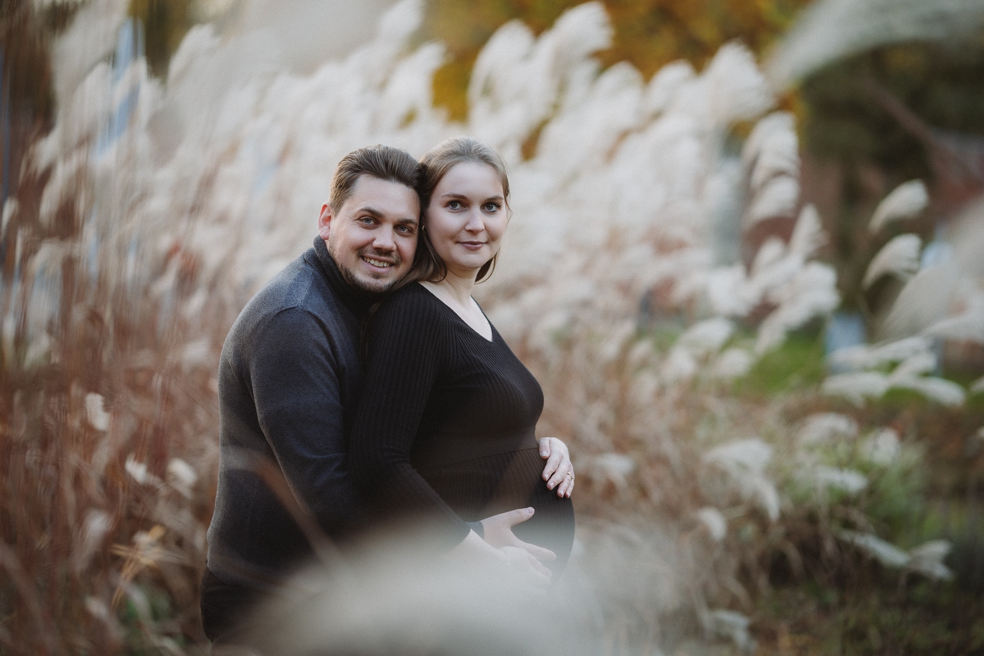 Schwangerschaftsfotografie Ulm, Paar mit Babybauch zwischen Pampasgras, natürliches Herbstportrait