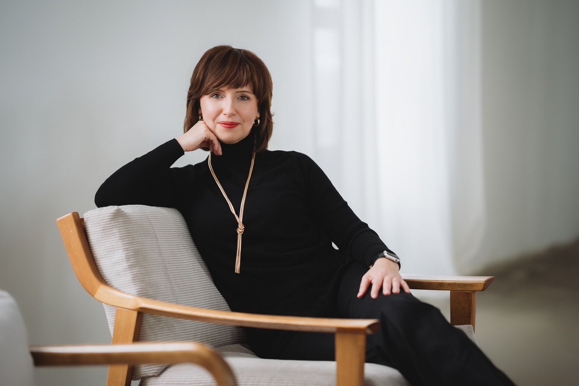 Personal Branding Fotografie Ulm, entspannte Unternehmerin im Sessel bei natürlichem Licht