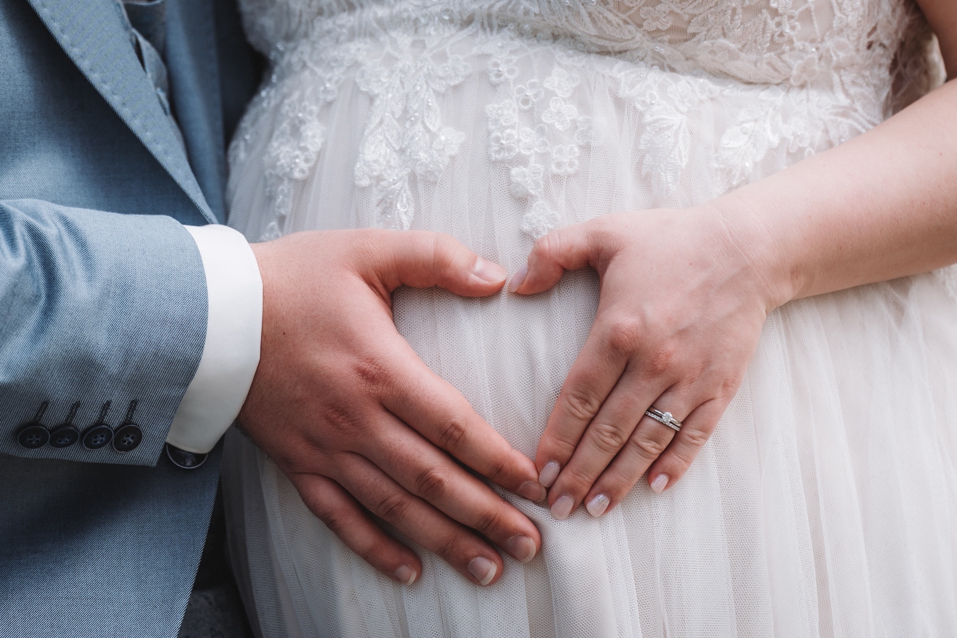 Hochzeitsfotografie Neu-Ulm, Brautpaar formt Herz mit Händen auf Babybauch, Glacis Park Neu-Ulm