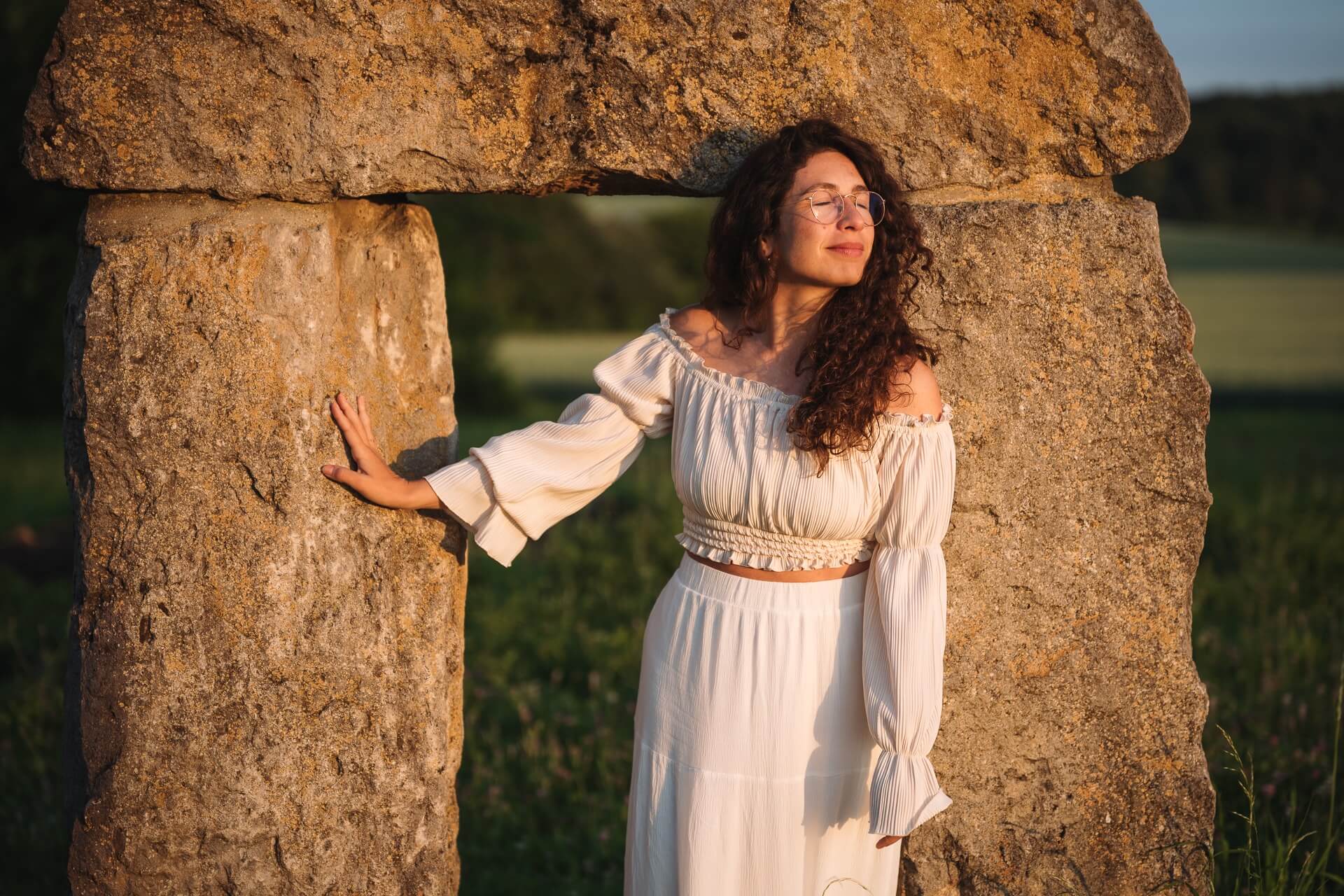 Outdoor Portrait Fotografin Ulm, Frau lehnt an Steintor im Abendlicht, Alisia D'Aniello